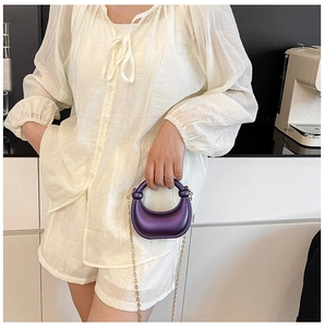 Chic purple crescent mini bag with gold chain strap shown on a model in a modern interior