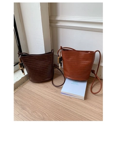 Close-up of woven bucket bags featuring natural wooden beads and fine rope straps