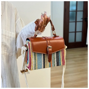 Detail der bunten Strohtasche mit brauner Lederklappe und dickem Seilschultergurt
