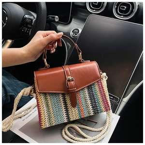 Detail der bunten Strohtasche mit Lederklappe und dickem Baumwollseil-Schultergurt