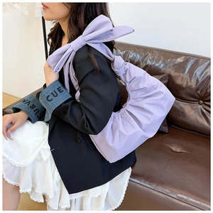 Detail of lavender pleated crescent bag with oversized decorative bow shoulder strap