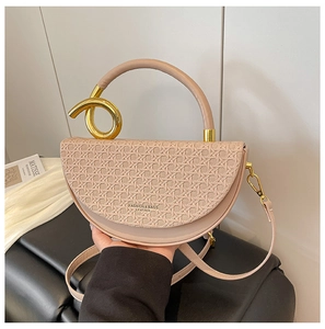 Detail of beige saddle bag featuring woven leather texture and golden twist ring handle