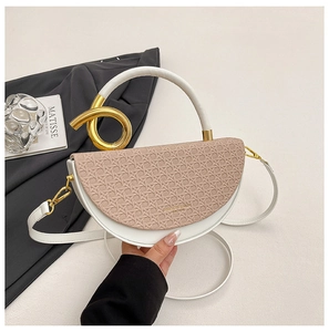 Detail of saddle bag featuring pink straw weave texture and gold metal ring handle