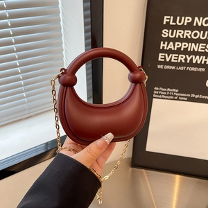 Burgundy crescent crescent moon saddle bag with round handle and gold chain strap