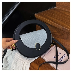 Detail of round leather bag with woven light blue flap and gold-trimmed oval buckle