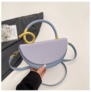 Detail of lavender woven saddle bag with gold-tone twist handle and blue textured body