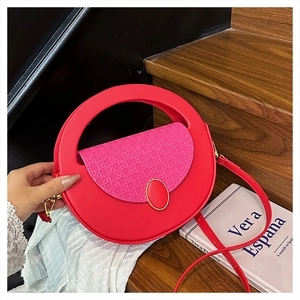 Detail of red semicircular crossbody bag with woven texture lid and golden jewel buckle
