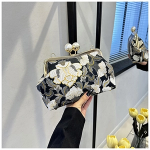 Détail de la broderie de pivoine et du fermoir perle sur ce sac de soirée noir élégant