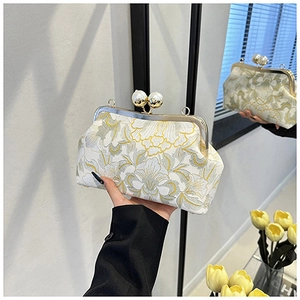 Détail de broderie florale sur le sac avec grand fermoir perle et cadre métallique
