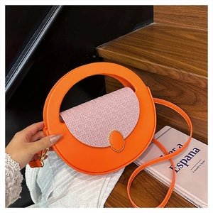 Detail of pink woven flap on orange crescent shoulder bag with golden oval buckle