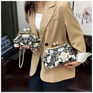 Détail du sac brodé vintage avec fermoir perle et bandoulière chaîne dorée