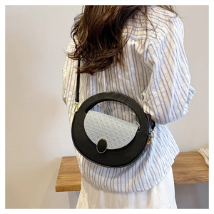 Detail of round crossbody bag with light blue textured flap on female model back view