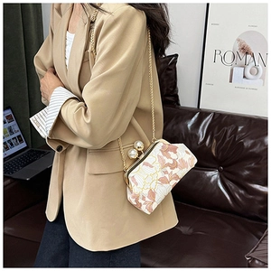 Détail d'un sac à cadre floral avec fermoir perle et chaîne en métal doré