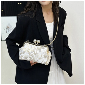 Détail du sac de soirée en jacquard floral avec fermoir perle et chaîne dorée