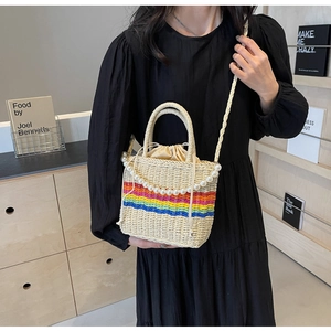 Detail of hand-woven straw crossbody bag with rainbow stripes and pearl beaded handle