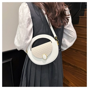 Close-up of white round crossbody bag with woven texture flap and golden metal buckle
