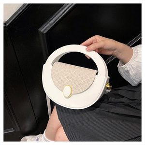 Close-up of white semi-circle handbag with large circular handle and woven lid detail