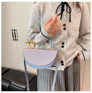 Detail of saddle bag featuring purple woven flap and unique gold ring metal handle