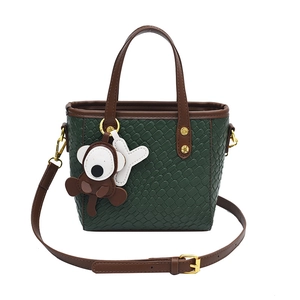 Sac cabas tissé vert foncé avec poignées en cuir marron et pendentif singe mignon