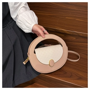 Detailed view of beige woven texture and golden oval buckle on a stylish crossbody bag