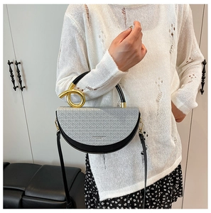 Detail of saddle bag featuring gray woven texture, black leather, and gold metal buckle