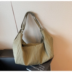 Detail of olive green pleated hobo bag featuring matte texture and adjustable strap