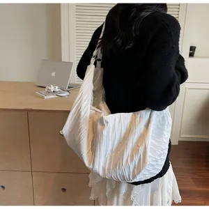 Detailed close-up of white pleated large capacity hobo shoulder bag with textured fabric