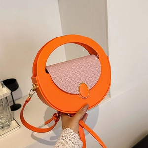 Retro round shoulder bag in bright orange with pink straw woven flap and circular handle
