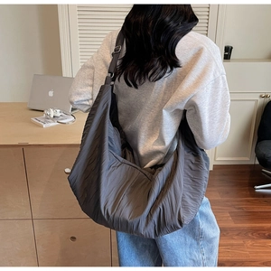 Detailed close-up of dark grey pleated hobo bag with adjustable wide shoulder strap