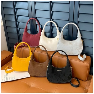 Close-up of hobo bags in six colors with matte suede texture and chain strap details