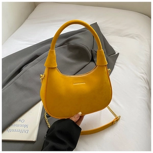 Close-up of yellow velvet hobo bag featuring gold metal chain and fashion brand logo