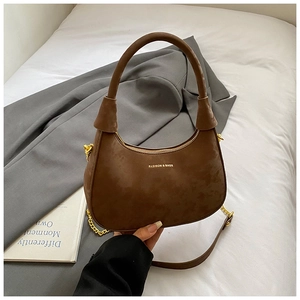 Close-up of brown velvet hobo bag with golden chain strap and smooth zipper detail