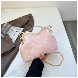 Detail of light pink shell bag showing rose embossed texture and gold metal clasp frame