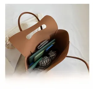 Detailed internal view showing large capacity for umbrella and tablet in brown tote bag