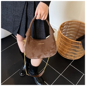 Brown velvet hobo bag featuring a golden chain strap and textured crescent shape