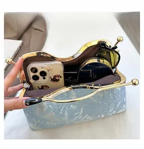 Detail view of the spacious blue jacquard shell bag with vintage gold metal clasp