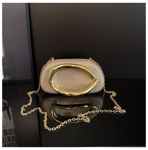 Detail of elegant gold rhinestone evening clutch with large round metal ring handle