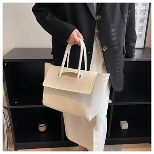 Close-up of cream large tote bag with top handle and premium leather texture details