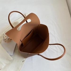 Internal view of a spacious brown tote bag with smooth texture and inner pocket