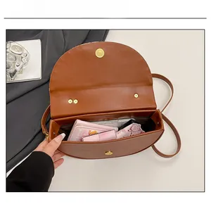 Interior view of brown faux leather saddle bag showing capacity for phone and wallet