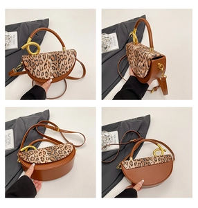 Detail view of leopard print half-moon bag with artistic golden spiral handle and leather strap