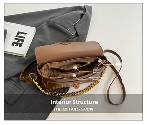 Detail view of the brown leather bag interior with main, zipper, and phone pockets