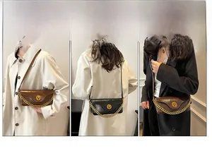 Detail view of vintage square underarm bags in black and brown with gold metal chain