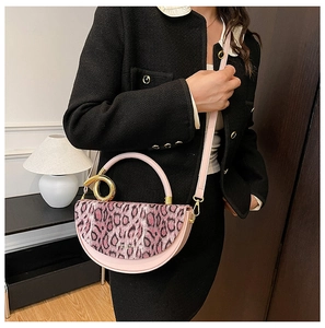 Detail of pink leopard print flap and gold metal ring handle on a luxury box bag