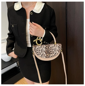 Detail of leopard print handbag with gold ring handle and beige leather trim texture