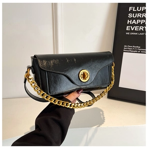 Detail of black vintage faux leather bag with round gold twist lock and thick chain strap