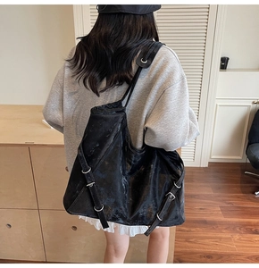 Détail d'un grand sac fourre-tout noir à texture vintage avec boucle à anneau en métal