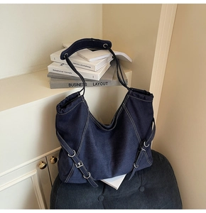 Détails du sac cabas en denim bleu foncé avec surpiqûres blanches et boucles métalliques