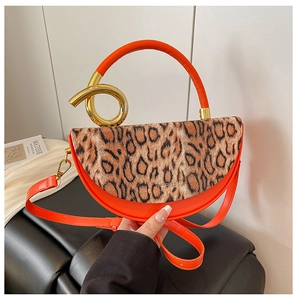 Detail of trendy leopard print flap and orange leather on a semi-circular handbag