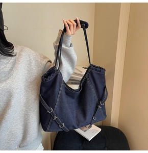 Détail du sac fourre-tout en denim bleu foncé avec surpiq coutures blanches et boucles métal